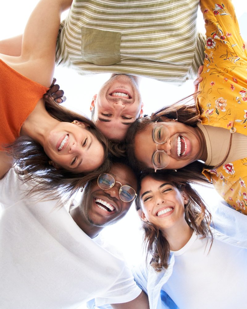 Vertical multiracial group young people standing in circle smiling at camera. Concept youth culture.